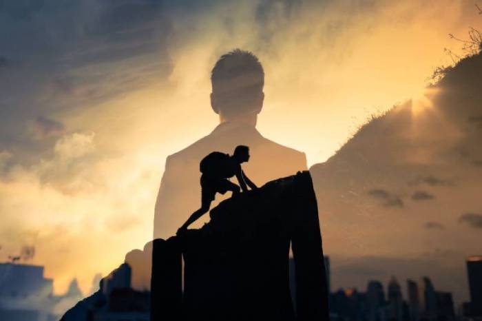 homme grimpant une montagne