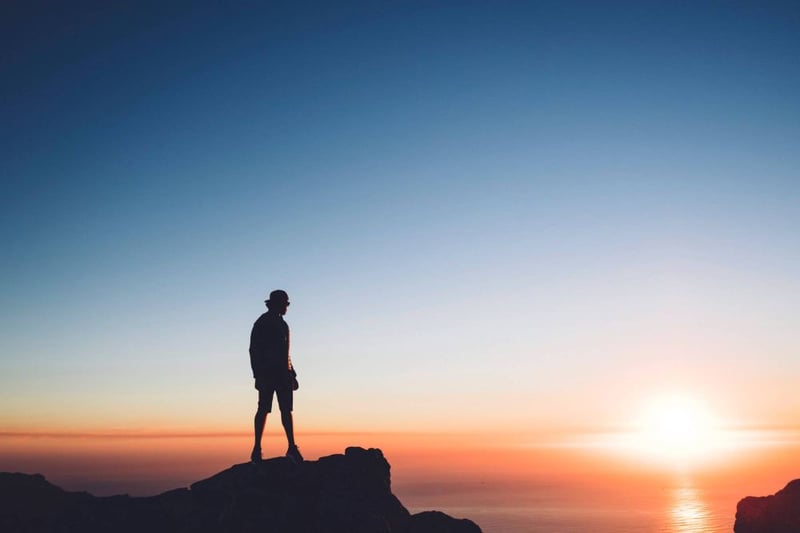 homme regardant vers le soleil couchant