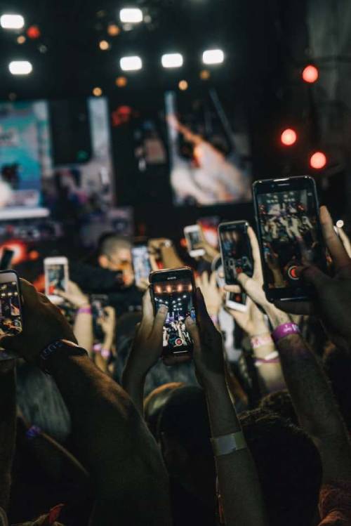 mains tenant des gsm pour filmer un événement