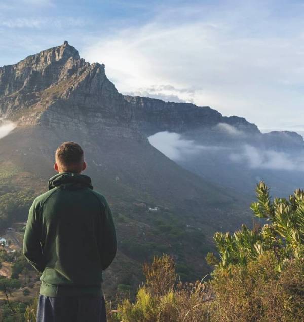 homme regardant vers un paysage montagneux représentant la portée du projet